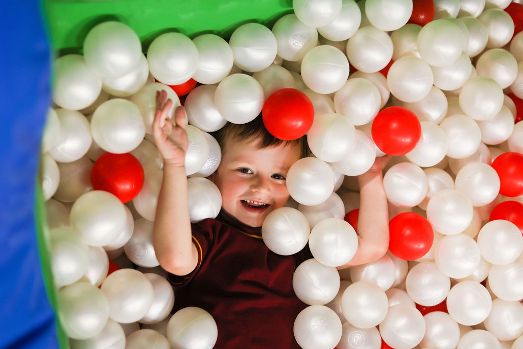 A small child enjoying the ball pool at a Bouncefest event.